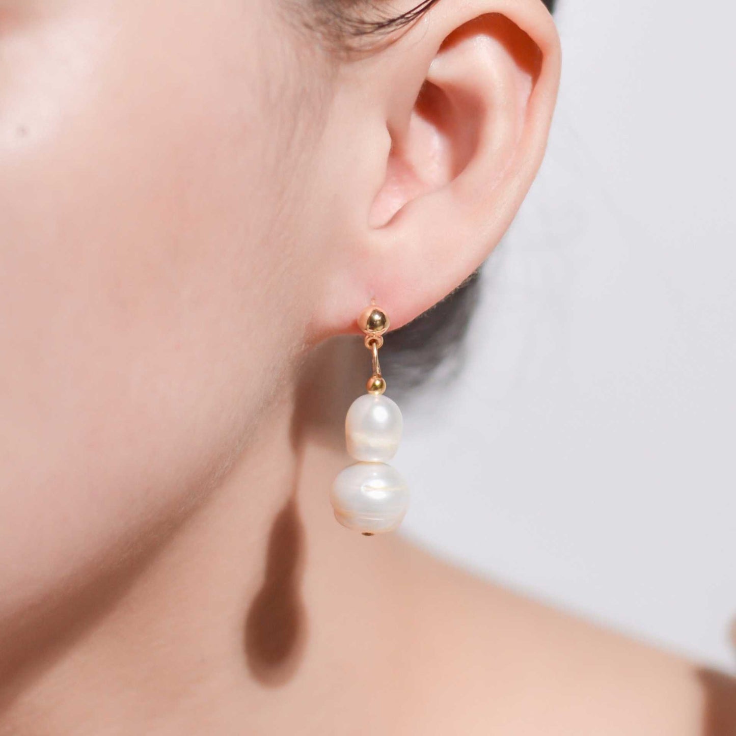 White oval and siopao dangling pearls yellow gold plated earrings