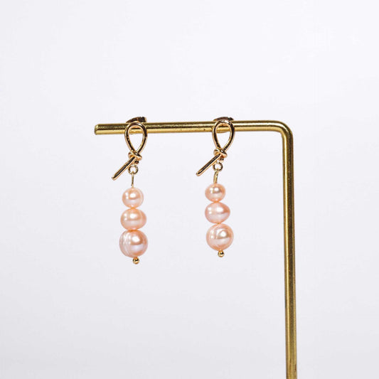 Tiered light pink pearls yellow gold plated dangling knot earrings
