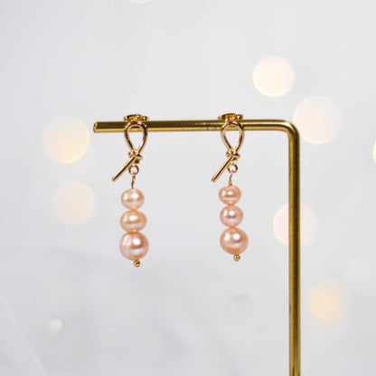 Tiered light pink pearls yellow gold plated dangling knot earrings